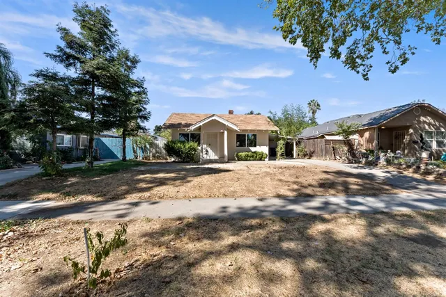 a front view of a house with a yard and car parked