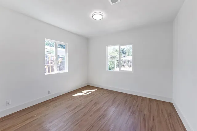 a bedroom with a large bed and wooden floor