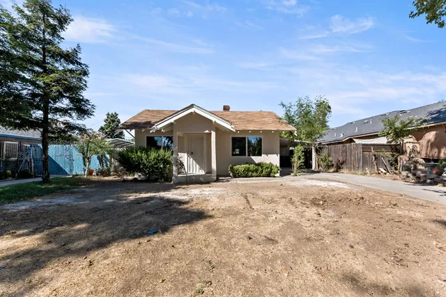 a front view of a house with a yard and trees