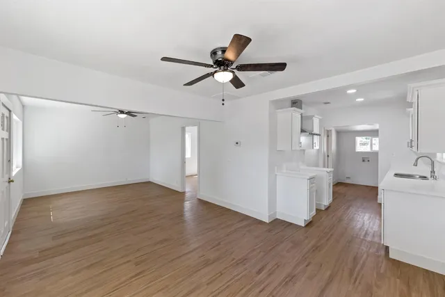 a kitchen with white cabinets sink and stove
