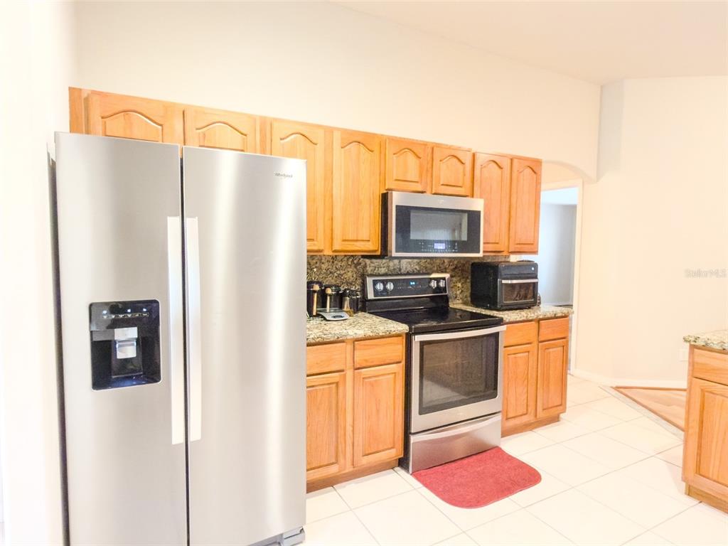4 Weston Road Leesburg, FL 34748 - Photo 13 of 55 a kitchen with stainless steel appliances a refrigerator and a stove top oven