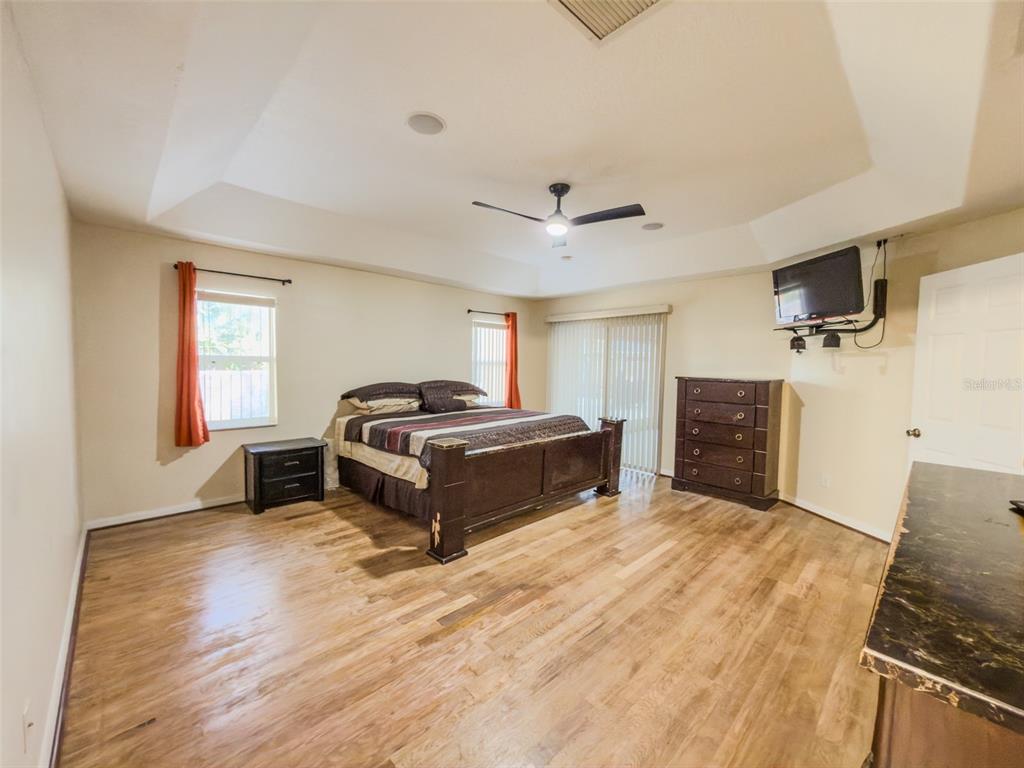 4 Weston Road Leesburg, FL 34748 - Photo 18 of 55 a spacious bedroom with a bed and a flat screen tv