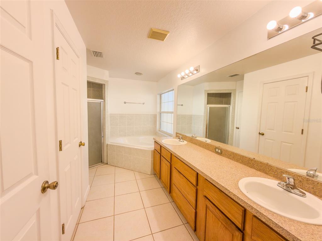 4 Weston Road Leesburg, FL 34748 - Photo 25 of 55 a spacious bathroom with a granite countertop sink a mirror and a bathtub