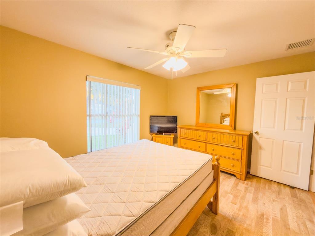 4 Weston Road Leesburg, FL 34748 - Photo 47 of 55 a bedroom with a bed and wooden floor