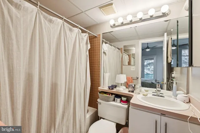 a bathroom with a sink vanity mirror and toilet