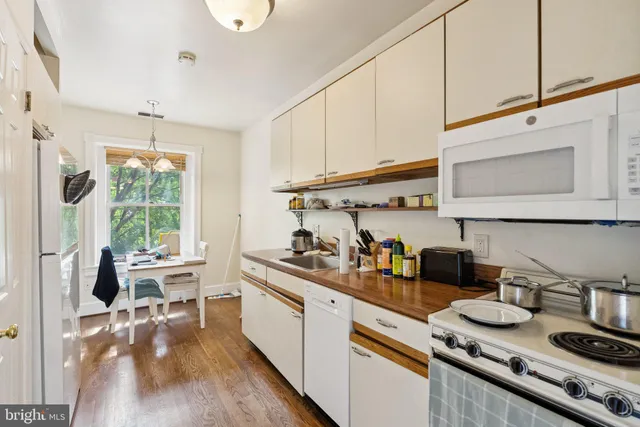 a kitchen with stainless steel appliances granite countertop a stove a sink dishwasher and cabinets with wooden floor