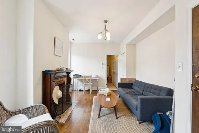 a living room with furniture a fireplace and a chandelier