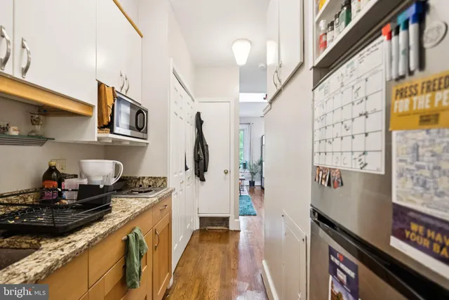 a kitchen with stainless steel appliances granite countertop a refrigerator a stove and a sink