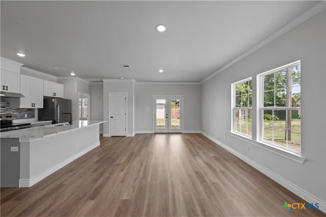 a view of empty room with wooden floor and window