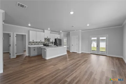 a large kitchen with stainless steel appliances granite countertop a large counter top a sink and a refrigerator