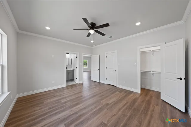 a view of a kitchen with a fridge and wooden floor
