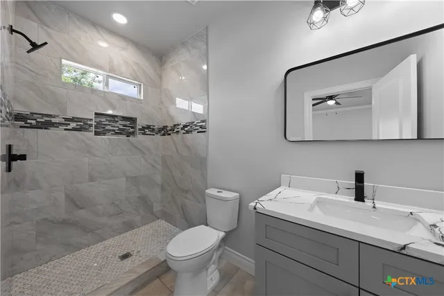 a bathroom with a toilet sink and mirror