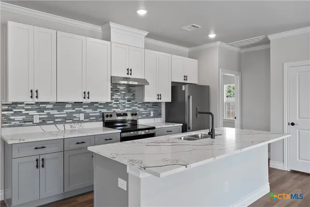 a kitchen with stainless steel appliances granite countertop a sink refrigerator and cabinets