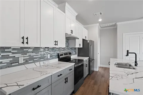 a kitchen with stainless steel appliances granite countertop a sink stove and refrigerator