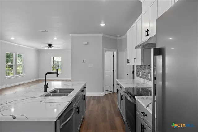 a kitchen with stainless steel appliances granite countertop a sink stove and refrigerator