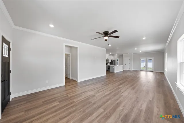 a view of a big room with wooden floor and a ceiling fan