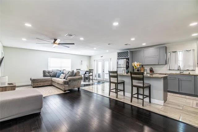 a living room with furniture kitchen and a wooden floor