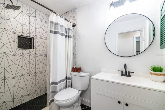 a bathroom with a sink a mirror a toilet and a shower