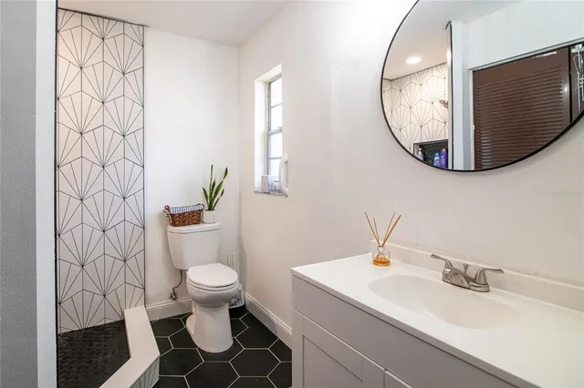 a bathroom with a sink mirror and toilet
