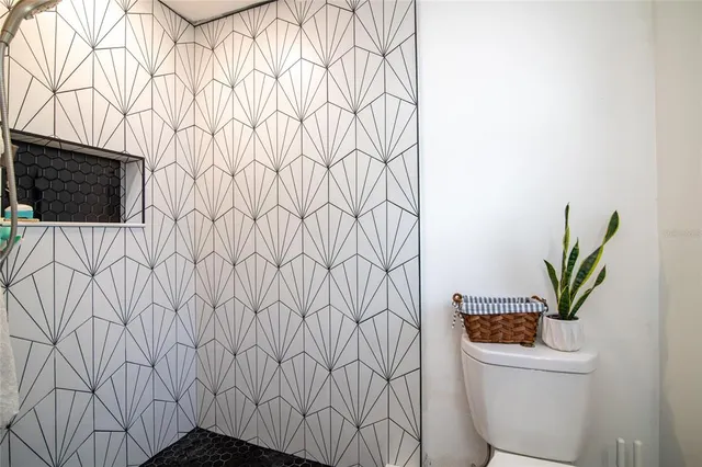 a bathroom with a toilet and a plant