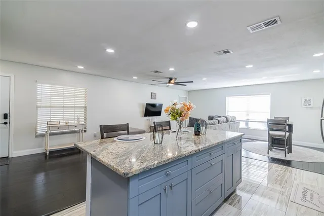 a kitchen with stainless steel appliances granite countertop sink stove and wooden floor