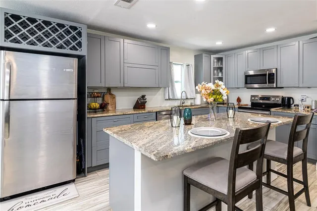 a kitchen with sink a refrigerator and chairs