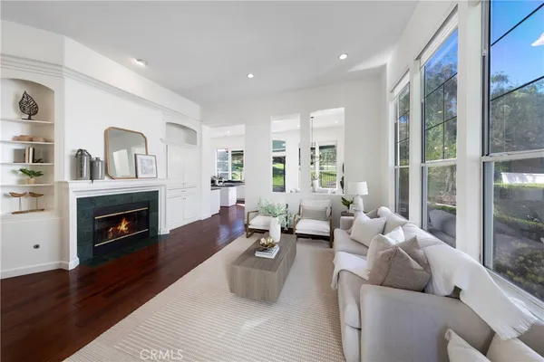 a living room with furniture a fireplace and a floor to ceiling window