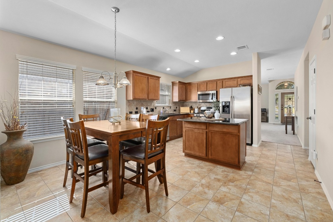 11201 Old Quarry Road Austin, TX 78717 - Photo 14 of 33 a kitchen with stainless steel appliances granite countertop a stove a sink a refrigerator a dining table and chairs