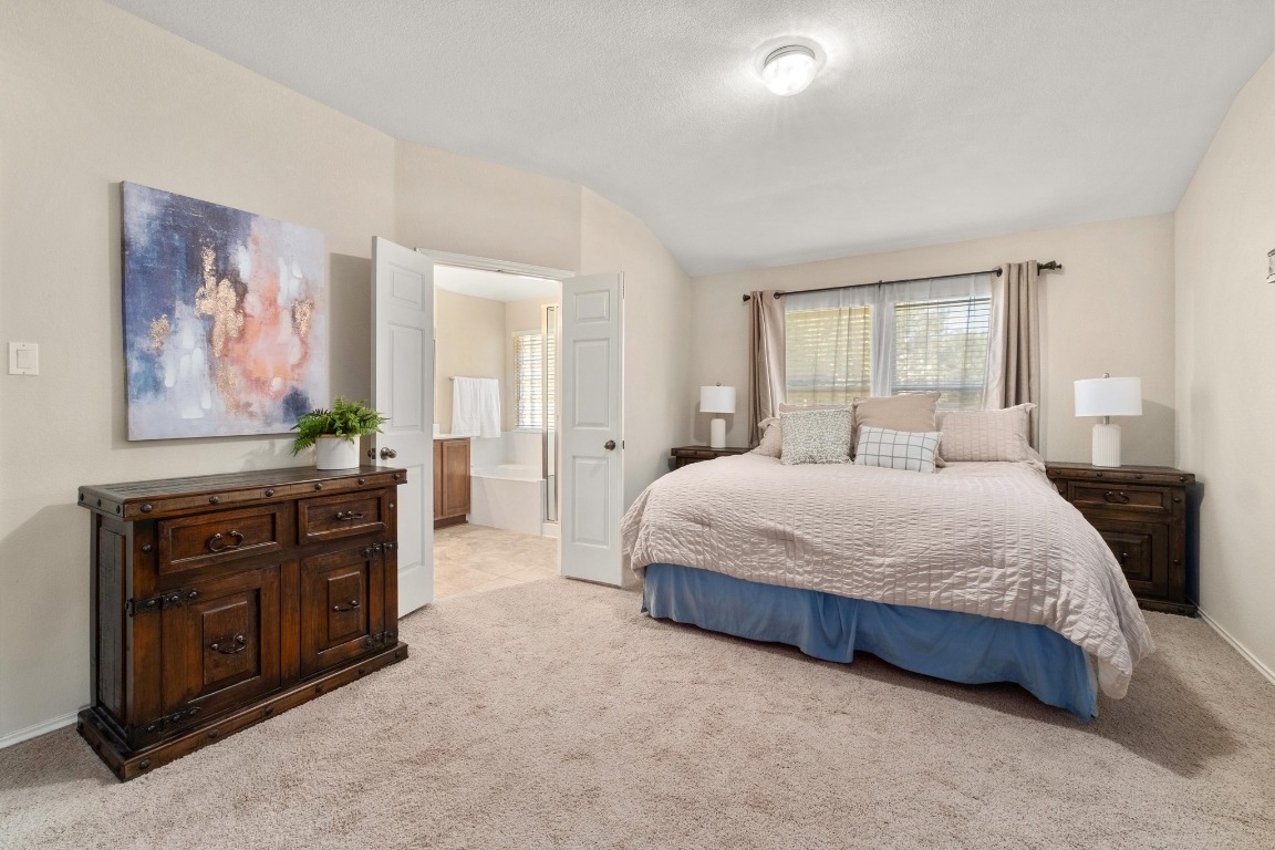 11201 Old Quarry Road Austin, TX 78717 - Photo 15 of 33 a spacious bedroom with a bed and a couch