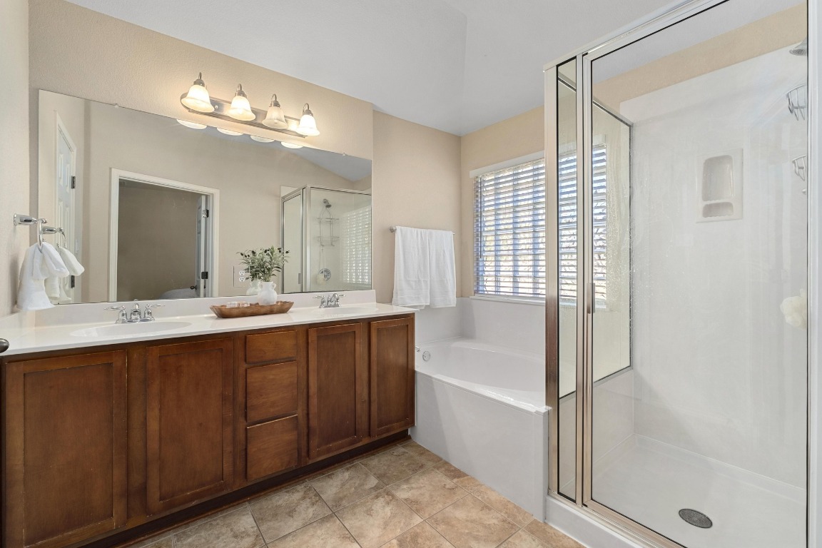 11201 Old Quarry Road Austin, TX 78717 - Photo 18 of 33 a spacious bathroom with a shower a sink and a mirror