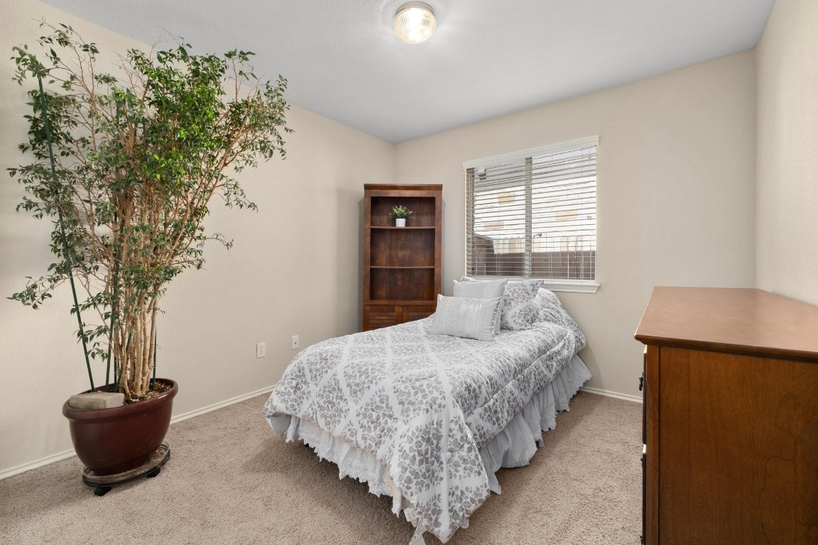 11201 Old Quarry Road Austin, TX 78717 - Photo 20 of 33 a bedroom with a bed and a potted plant