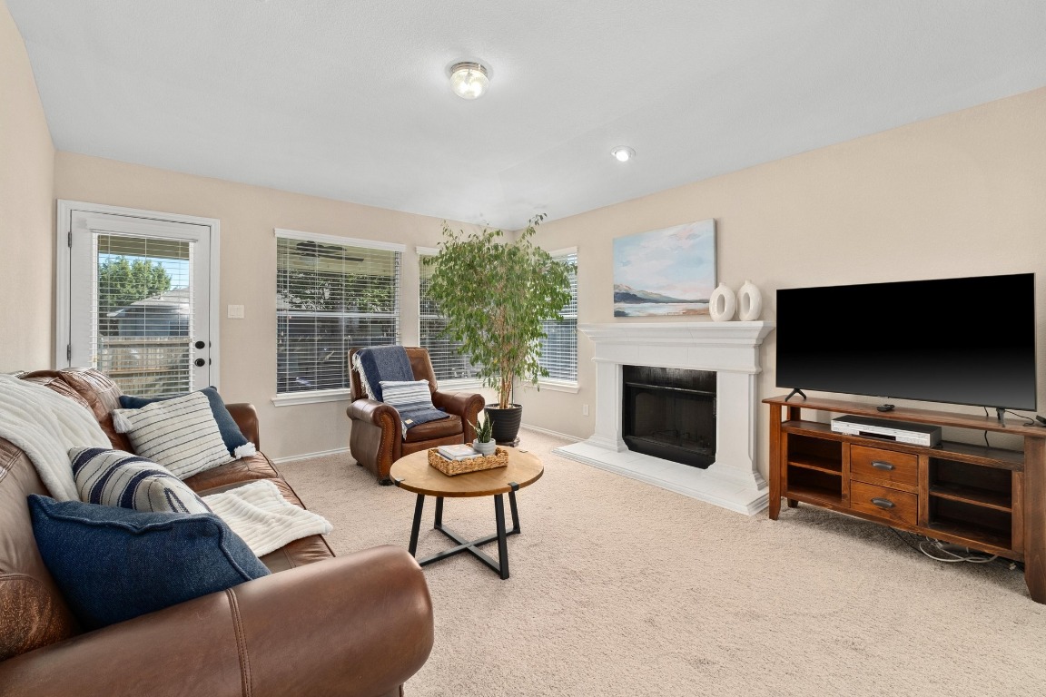 11201 Old Quarry Road Austin, TX 78717 - Photo 8 of 33 a living room with furniture a flat screen tv and a fireplace