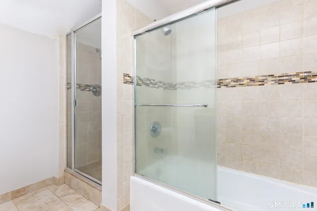 a bathroom with a shower and a bath tub
