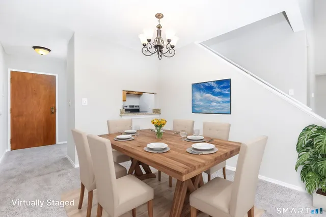 a view of a dining room with furniture a chandelier and wooden floor