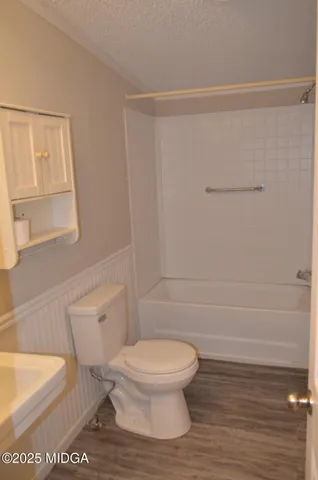 a white toilet sitting next to a bathroom sink and vanity