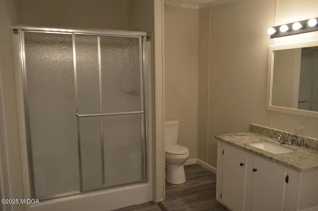 a bathroom with a granite countertop sink toilet and shower