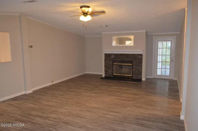 a view of empty room with wooden floor and fireplace