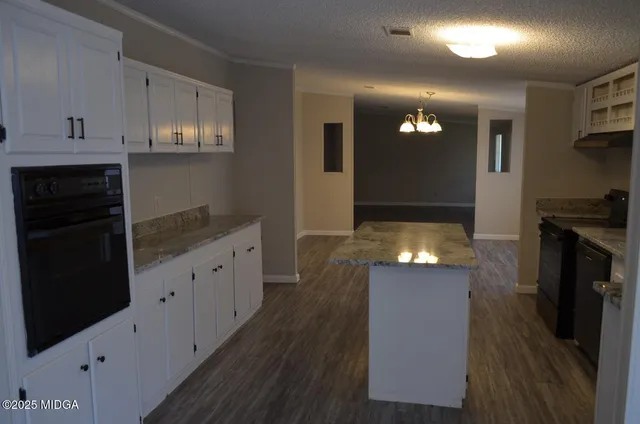 a kitchen with granite countertop a stove and a refrigerator