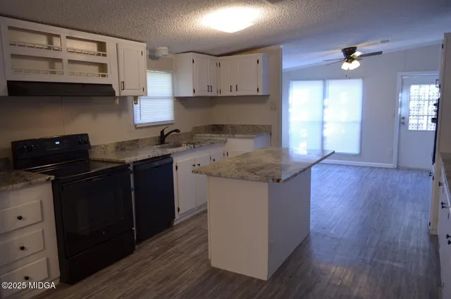 a kitchen with stainless steel appliances granite countertop a sink stove and wooden floor