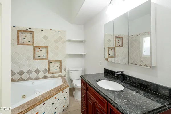 a bathroom with a granite countertop sink tub double vanity and shower