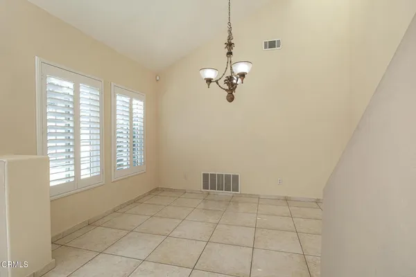 a view of empty room with windows and chandelier fan