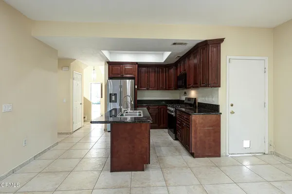 a kitchen with stainless steel appliances granite countertop a stove a sink and a refrigerator