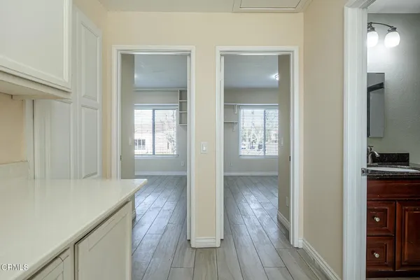 a view of a hallway with wooden floor and closet