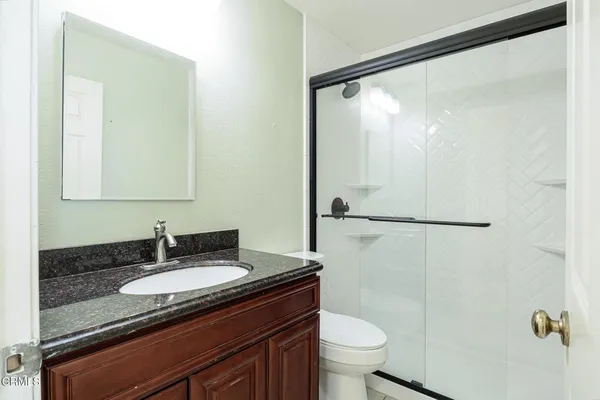 a bathroom with a granite countertop sink toilet and shower