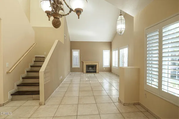 a view of an empty room with windows and fireplace