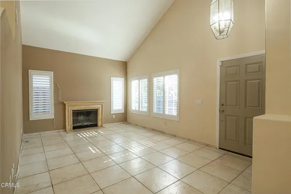 a view of an empty room with a fireplace and a window