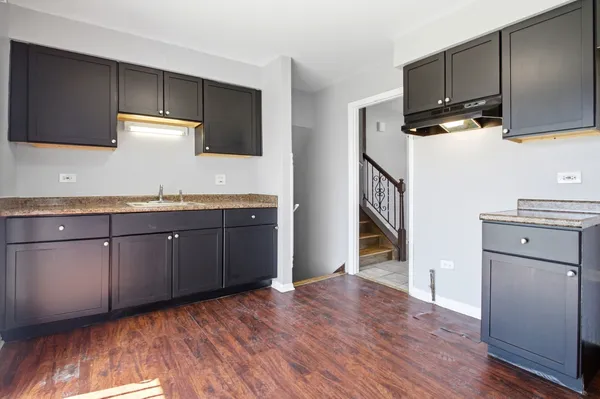a kitchen with a sink cabinets and wooden floor