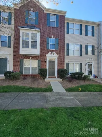 a front view of a house with a yard and plants