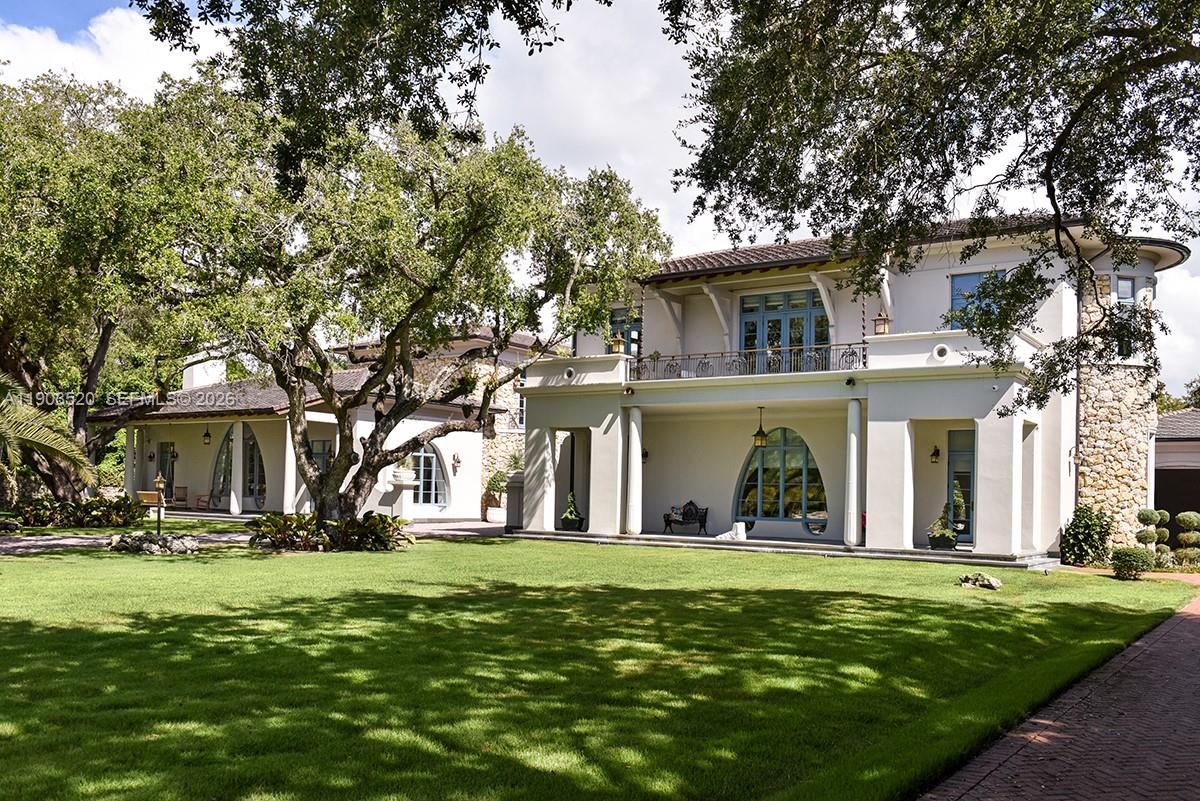 5771 Southwest 94th Street Pinecrest, FL 33156 - Photo 22 of 47 a view of a white house with a big yard and large trees