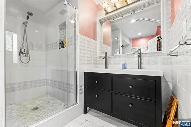 a bathroom with a shower sink and mirror